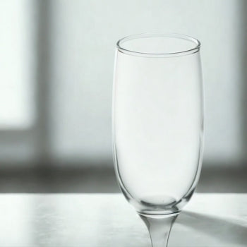 Side view of a single clear flute glass highlighting the slender stem and tapered bowl