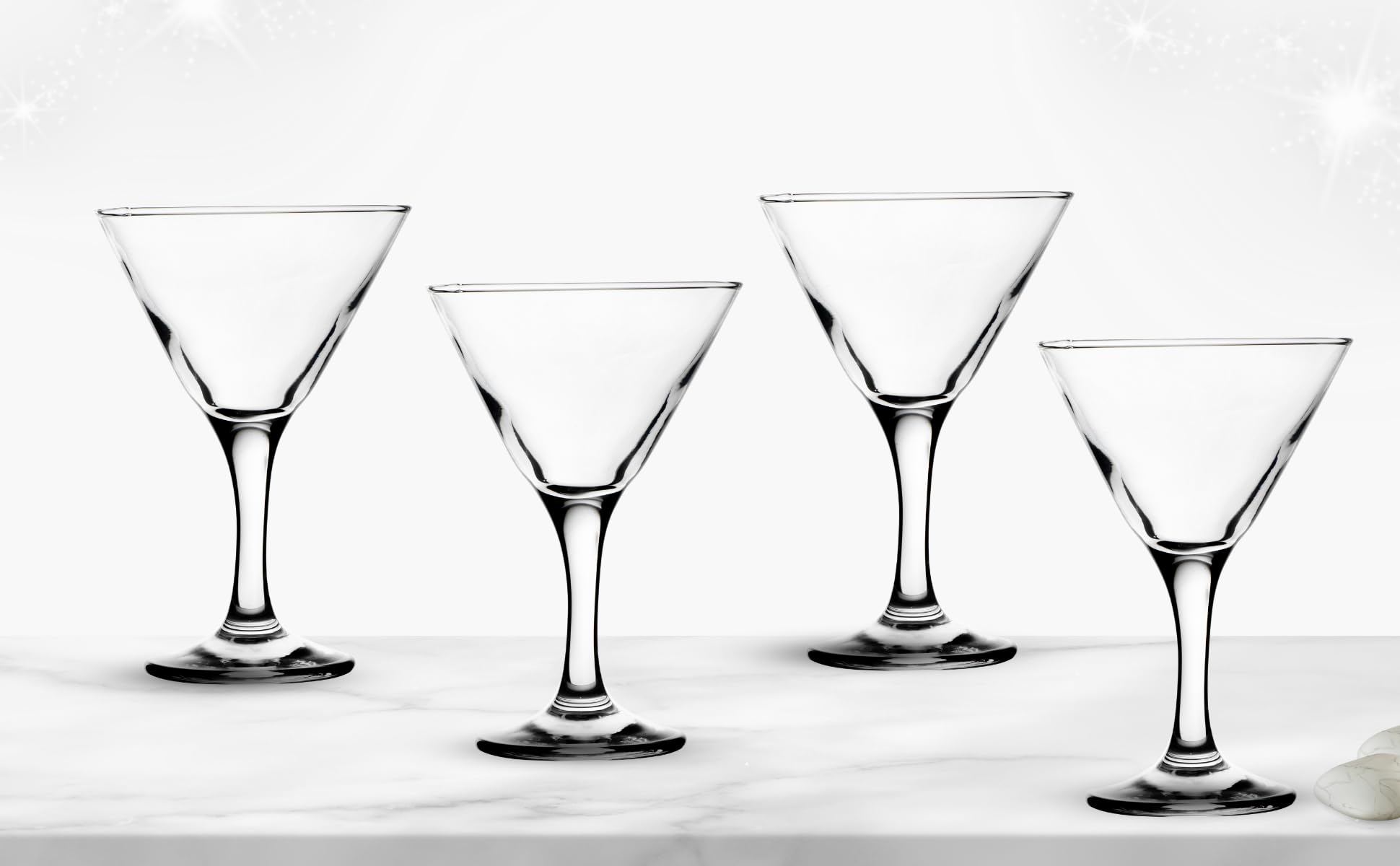 Martini glass filled with a classic olive garnish cocktail on a bar counter