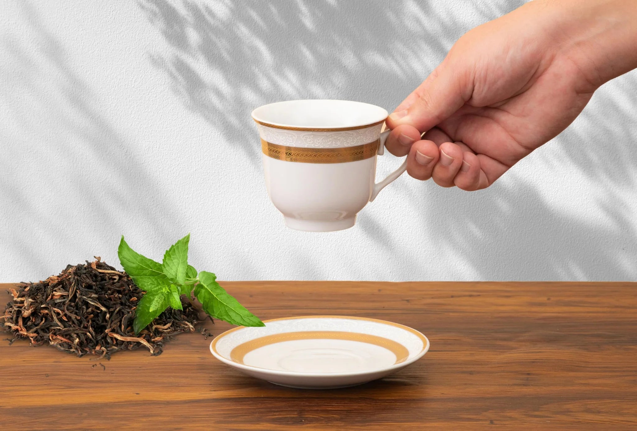 Porcelain cup and saucer from the dinnerware set styled on a table with a morning coffee setting