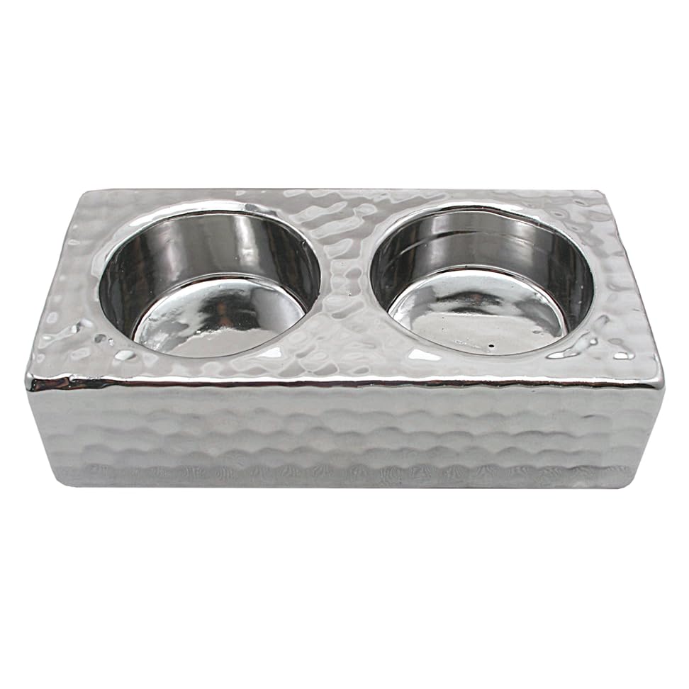 Silver double tealight holder with embossed design displayed on a flat surface, showing full acute-angled stand profile